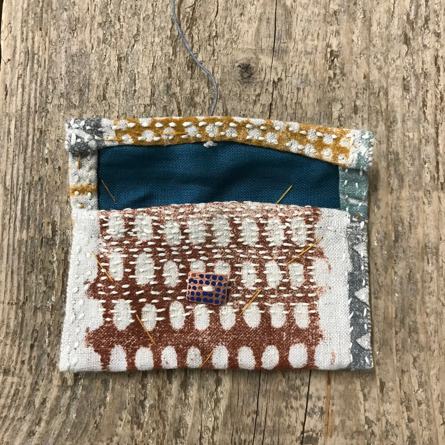 hand stitched keepsake pouch with copper buttons